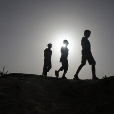 Three Palestinians walking as hundreds of thousands flee Rafah in southern Gaza