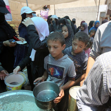 Children and some adults hold pots as they queue for rice in Gaza 