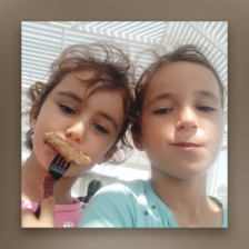 A close-up of two girls smiling and having a snack