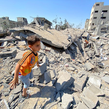 A boy moves through the remains of buildings in Gaza 