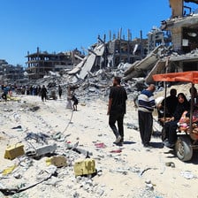 People go through a destroyed refugee camp on foot and in carts 
