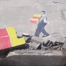 A colorful graffiti depicts a man carrying building blocks