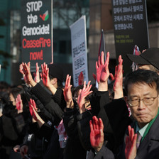 Protestors in Seoul hold up placards demanding an end to the genocide in Gaza