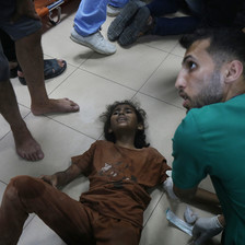 An injured child screams in pain on the floor of a hospital