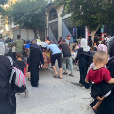 Parents holding children and others evacuate a Gaza City neighborhood