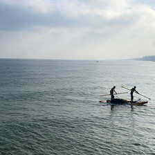 Two fishers at sea in a small boat 