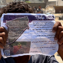 A person holds up an evacuation notice from Israel