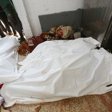 A number of dead bodies covered by shrouds 