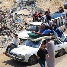 People sit on top of car with a mattress and other items on its room 