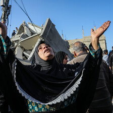 A woman raises her hands to the sky