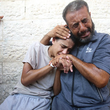 Man and boy cry as they embrace on another 