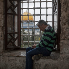 Aman sits by a window overlooking the Aqsa mosque