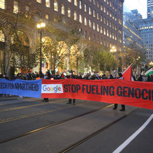 Demonstrators block a street with two large banners 