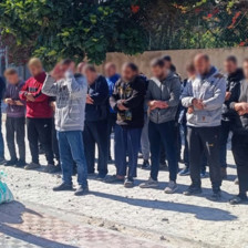 A group of people pray on a pavement