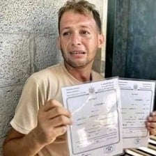  A tearful man holds up to certificates 