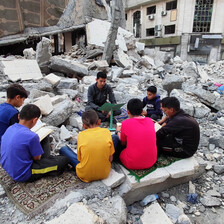 children read amid rubble