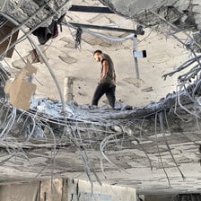 Photo taken from below shows man walking next to hole in floor of multi-story building