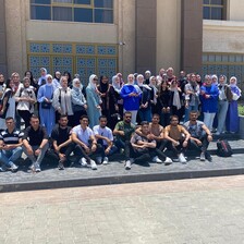 A group of students pose on the steps of a building