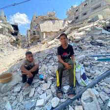 two boys sit on rubble