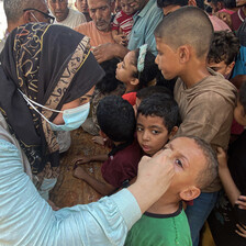 A woman administers a vaccine to a child