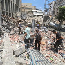 people look through rubble after an Israeli airstrike