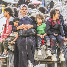 A Palestinian woman and children on a cart depart Jabaliya