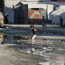 A girl walks through a puddle