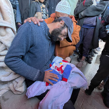 A man prepares his infant for burial