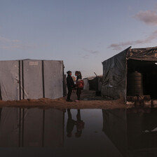 a large puddle lies between two tents