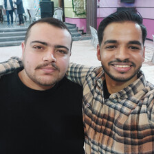 Selfie of two young men embracing while standing in wedding hall