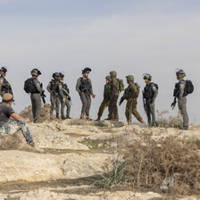 A number of Israeli soldiers and settlers on a hilltop in the occupied West Bank 