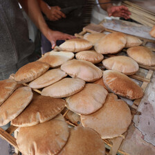 Freshly baked bread piled near an oven