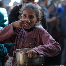 A child eats from a pot