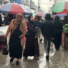 People walk through a market in the rain