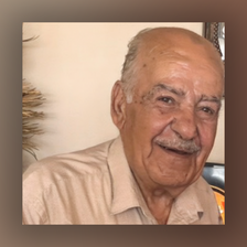 A close-up photo of an elderly man smiling.