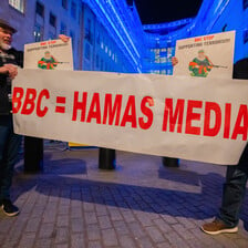 Protestors hold up a banner equating the BBC with Hamas