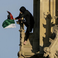 A man waves the Palestinian flag from a perch on Big Ben