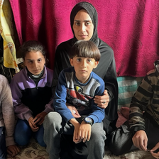 A woman sits with four children