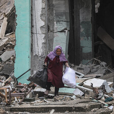 A woman carries two heavy bags