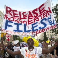 Demonstrators hold a sign reading: Release the Jeffrey Epstein files now