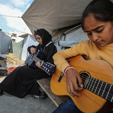 Two girls play guitar