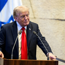Trump speaks in front of an Israeli flag