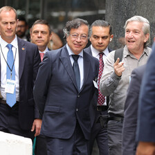 A man in a suit flanked by others in suits