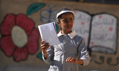 Girl in school uniform holds book