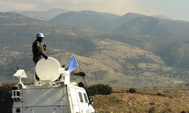 UN soldier atop armored vehicle overlooks Lebanon-Israel border