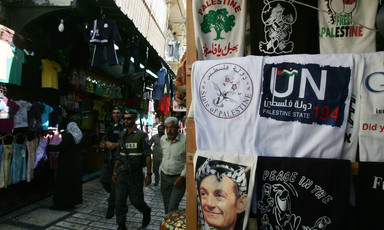 Israeli police walk by display of T-shirts marketed to tourists