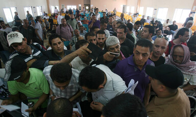 Men holding passports crowd at crossing terminal