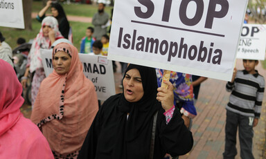 Woman carries sign reading Stop Islamophobia