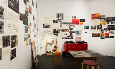 Brightly-lit room with collage of photographs on walls