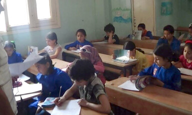 Children sit at school desks